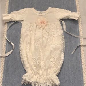 Onesie lace outfit with floral appliqué in front.